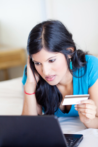 Frustrated woman holding credit card